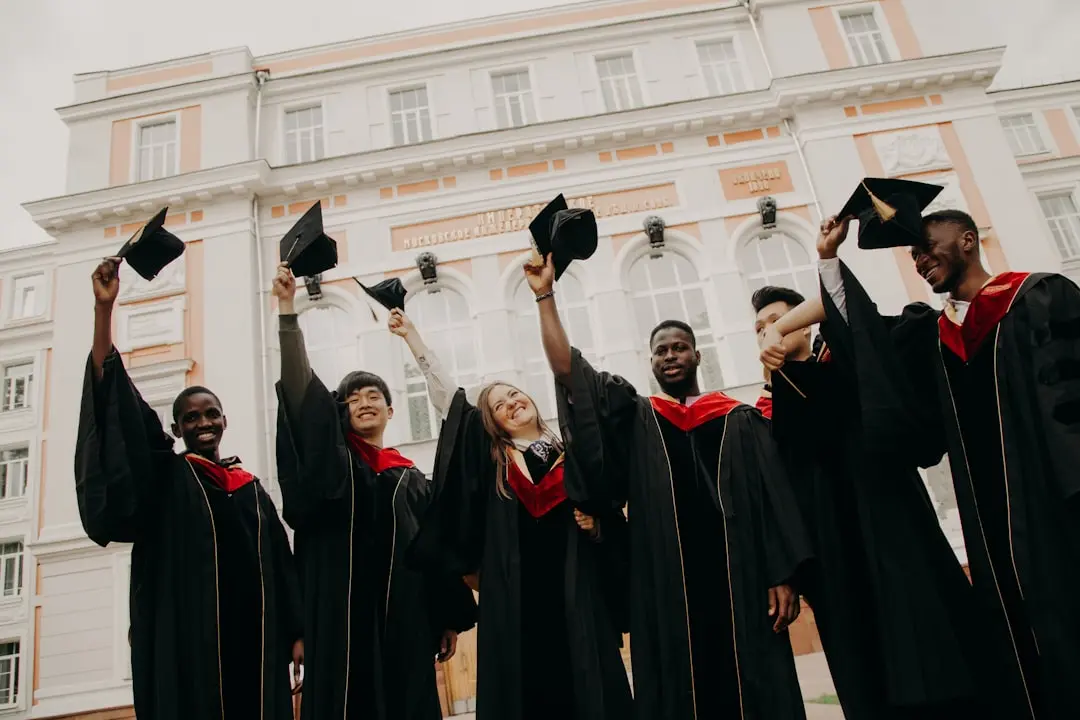 A group of happy, diverse students celebrating their graduation on a university campus.